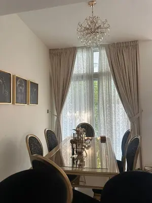 a dining room table with chairs and a chandelier at Villa Townhouse in Dubai