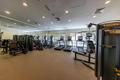 a gym with rows of treadmills and elliptical machines at VIP Experience Dubai Downtown at Boulevard Central T2 - Burj Khalifa View - Modern Luxury Apartments in Dubai