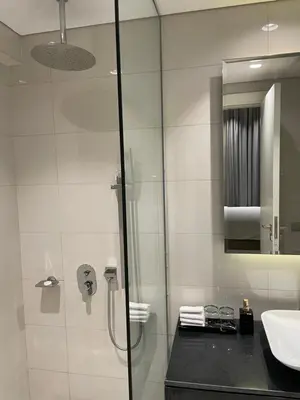 a bathroom with a glass shower and a sink at Damac Majestine VIP - Manzar Holiday Homes in Dubai