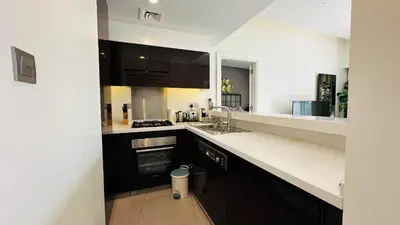 a kitchen with black cabinets and white counter tops at Damac Majestine VIP - Manzar Holiday Homes in Dubai