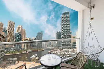 a balcony with chairs and a view of a city at Classic Charm a Studio with Iconic Marina Views in Dubai
