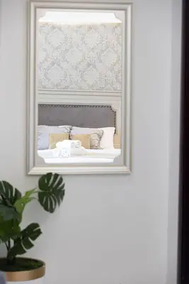 a mirror on a wall with a bed in a room at Classic Charm a Studio with Iconic Marina Views in Dubai