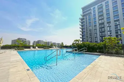 a large swimming pool in front of a tall building at Captivating 2BR Apartment in Park Ridge Tower C , Dubai Hills Estate by Deluxe Holiday Homes in Dubai