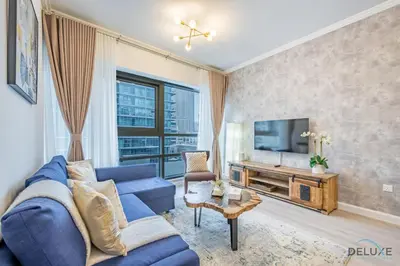 a living room with a blue couch and a tv at Stylish 1BR Apartment in Al Sahab 2, Dubai Marina by Deluxe Holiday Homes in Dubai