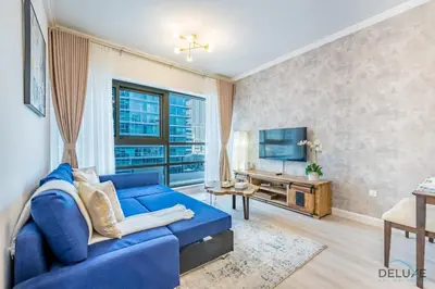 a living room with a blue couch and a tv at Stylish 1BR Apartment in Al Sahab 2, Dubai Marina by Deluxe Holiday Homes in Dubai