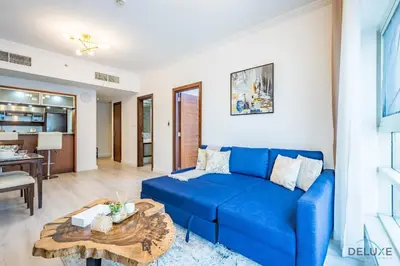 a living room with a blue couch and a table at Stylish 1BR Apartment in Al Sahab 2, Dubai Marina by Deluxe Holiday Homes in Dubai