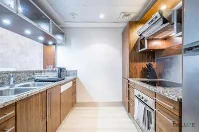 a kitchen with wooden cabinets and a sink at Stylish 1BR Apartment in Al Sahab 2, Dubai Marina by Deluxe Holiday Homes in Dubai