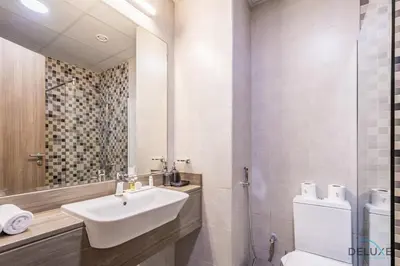 a bathroom with a sink and a toilet and a mirror at Stunning Studio Apartment in Azizi Star , Jebel Ali by Deluxe Holiday Homes in Dubai
