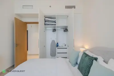 a white bedroom with a bed and a closet at Clever Guest 027 Acacia A in Dubai