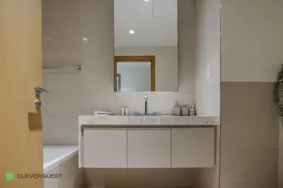 a white bathroom with a sink and a mirror at Clever Guest 027 Acacia A in Dubai
