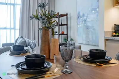a dining room table with plates and glasses on it at Clever Guest 027 Acacia A in Dubai