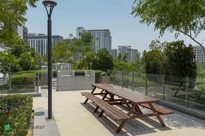 a wooden picnic table sitting next to a light pole at Clever Guest 027 Acacia A in Dubai