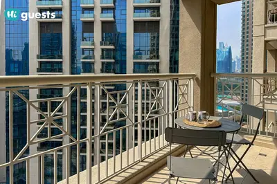 a table and chair on a balcony with buildings at HiGuests - Exclusive Downtown Dubai 1BR Apt at 29 Boulevard in Dubai