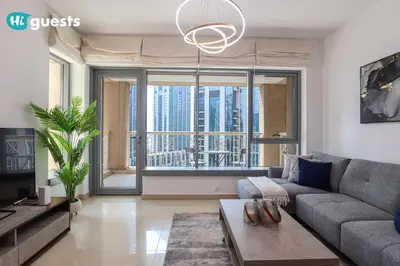 a living room with a couch and a large window at HiGuests - Exclusive Downtown Dubai 1BR Apt at 29 Boulevard in Dubai