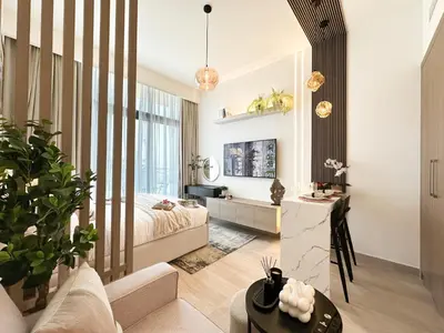 a bedroom with a bed and a desk in a room at Trophy Modern Marvel Cozy Studio with Smart Features in Azizi Riviera in Dubai