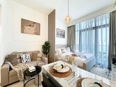 a living room with a couch and a bed at Trophy Modern Marvel Cozy Studio with Smart Features in Azizi Riviera in Dubai