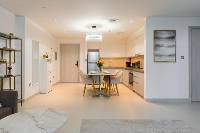 a kitchen and living room with a table and chairs at Dubai Creek - Bright & Beautiful 1BR in The Cove in Dubai