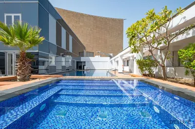 an infinity swimming pool in a villa with a building at Stylish Studio at Sky Gardens, DIFC by Deluxe Holiday Homes in Dubai