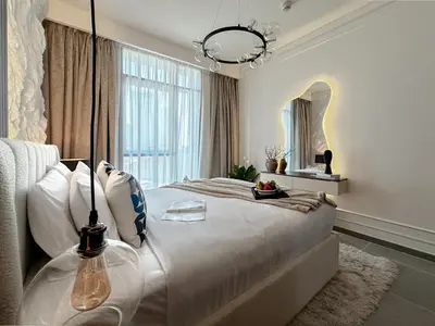 a bedroom with a large bed with a large window at Trophy - Ultra Luxury Suite with Fireplace in Dubai