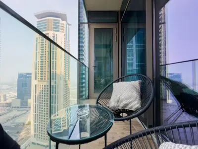 a balcony with a glass table and chairs on a building at Naseem - Stylish 1BR Hotel Apartment Overlooking the Marina in Dubai