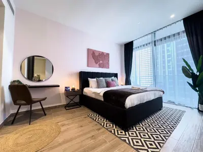 a bedroom with a bed and a mirror and a chair at Naseem - Stylish 1BR Hotel Apartment Overlooking the Marina in Dubai