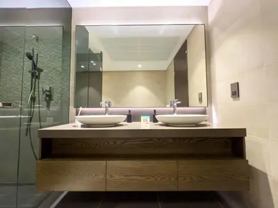 a bathroom with two sinks and a mirror at Naseem - Stylish 1BR Hotel Apartment Overlooking the Marina in Dubai