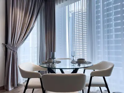 a dining room with a table and chairs and a large window at Naseem - Stylish 1BR Hotel Apartment Overlooking the Marina in Dubai