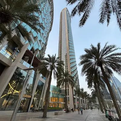 a group of palm trees in front of a tall building at Stunning Burj Khalifa & Fountain view - Dubai Mall Access, Burj vista Downtown Dubai in Dubai