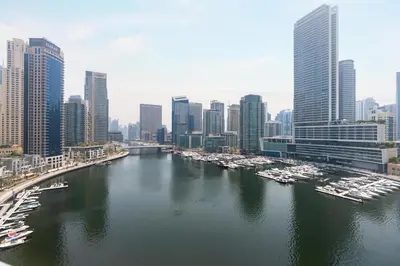 a river with boats in a city with tall buildings at Gala Guests - Stunning Front-Row Marina Views at The Point in Dubai