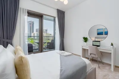 a bedroom with a bed and a desk and a mirror at Gala Guests - Deluxe Sparkle Residences Dubai Marina in Dubai