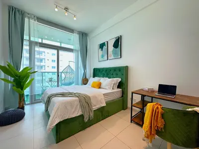a bedroom with a bed and a table with a laptop on it at Luxury RoofTop Pool with Full Marina View 45 percent OFF in Dubai