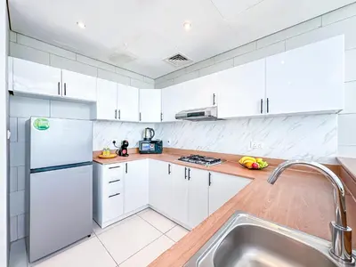 a white kitchen with white cabinets and a sink at Luxury RoofTop Pool with Full Marina View 45 percent OFF in Dubai