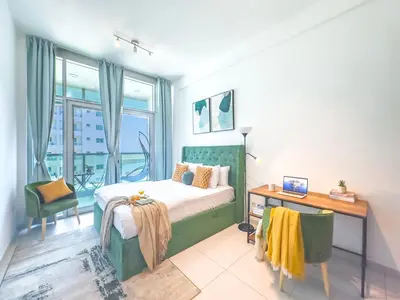 a bedroom with a bed and a desk and a window at Luxury RoofTop Pool with Full Marina View 45 percent OFF in Dubai