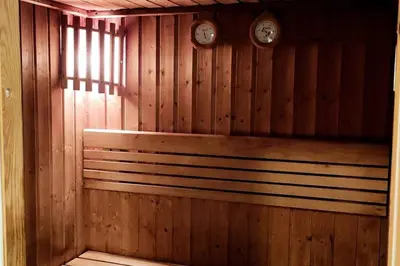 a wooden sauna with two clocks on the wall at Skyline & Lake views - Home Cinema - 1-BHK - Prime Location in Dubai