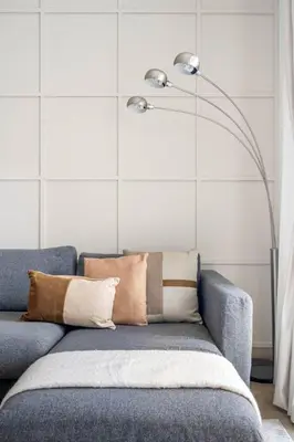 a blue couch with pillows and a floor lamp at GuestReady - Lux nest near JBR beach in Dubai