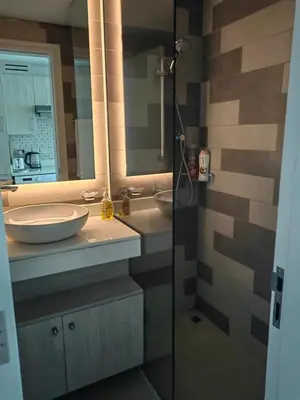 a bathroom with a shower and a sink and a mirror at 7 palm jumeirah West Beach in Dubai