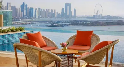 a patio with chairs and a table with a view of the city at 7 palm jumeirah West Beach in Dubai