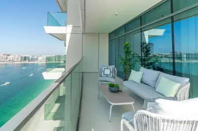 a balcony with a couch and chairs on a building at Beach Vista 2 - Beachfront Stunning - Full Sea Views in Dubai