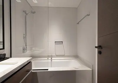 a white bathroom with a tub and a shower at Palace Residences 2BR with Stunning Creek Views in Dubai