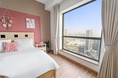 a bedroom with a large window with a view of a city at Aesthetic Beach Apartment , Sleeps 6, Pool, Gym & Waterfront Views in Dubai