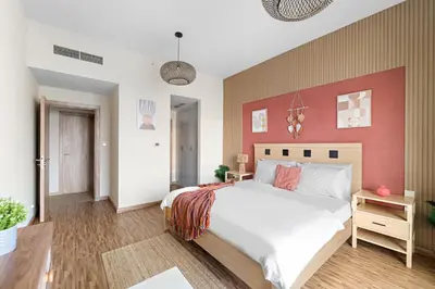a bedroom with a large bed with a red wall at Aesthetic Beach Apartment , Sleeps 6, Pool, Gym & Waterfront Views in Dubai