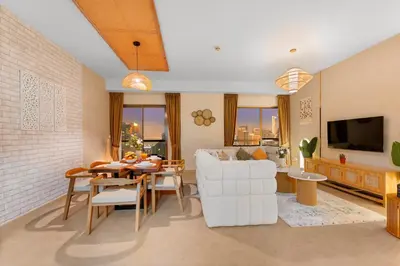 a living room with a white couch and a table at Aesthetic Beach Apartment , Sleeps 6, Pool, Gym & Waterfront Views in Dubai