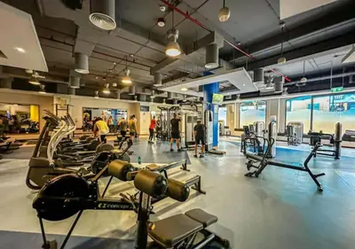 a gym with many treadmills and people in it at Aesthetic Beach Apartment , Sleeps 6, Pool, Gym & Waterfront Views in Dubai