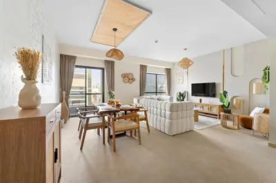 a living room with a table and a couch at Aesthetic Beach Apartment , Sleeps 6, Pool, Gym & Waterfront Views in Dubai
