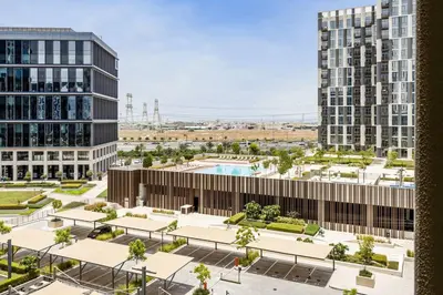 an aerial view of a building with a pool at Luxury at Socio Dubai Hills, 2 Beds, Sleeps 4 - DVH Holiday Homes in Dubai