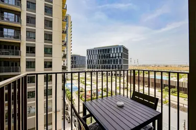 a balcony with a table and a view of a city at Luxury at Socio Dubai Hills, 2 Beds, Sleeps 4 - DVH Holiday Homes in Dubai