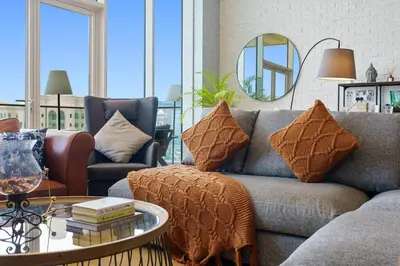 a living room with a couch and a table at Stellar 2BR on Palm Jumeirah - Beach and Pool access in Dubai