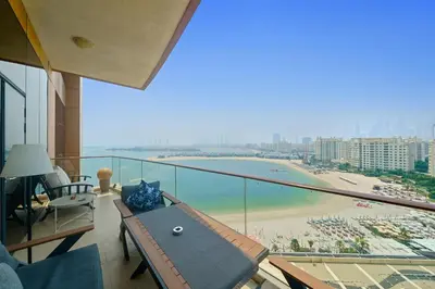 a balcony with a table and a view of a beach at Stellar 2BR on Palm Jumeirah - Beach and Pool access in Dubai