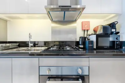 a kitchen with a stove and a sink at A Living-Modern Studio Apartment with Balcony & Canal view at Prive 2507B ,Business Bay in Dubai