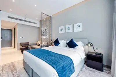 a bedroom with a large bed with a blue blanket at A Living-Modern Studio Apartment with Balcony & Canal view at Prive 2507B ,Business Bay in Dubai